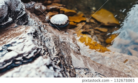 Rocky shoreline with calm water and shells at midday Rocky shoreline with calm water and shells at midday 132678865