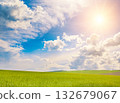 Bright midday sun in blue sky with cirrus clouds over wheat field. 132679067