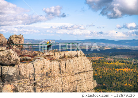 Visitors stand on the lookout point at Southern Terraces in Stolowe Mountains National Park, admiring scenic views of autumn colors in the landscape. A perfect spot for nature enthusiasts. 132679120