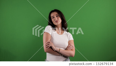 Fashion model posing with crossed arms on green screen background Fashion model posing with crossed arms on green screen background 132679134