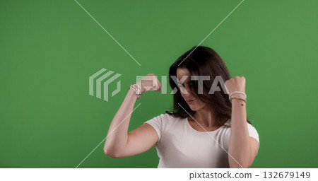 Fashion model showing strength and power on green screen background Fashion model showing strength and power on green screen background 132679149