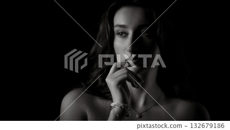 Fashion model posing in black and white with hand on chin Fashion model posing in black and white with hand on chin 132679186