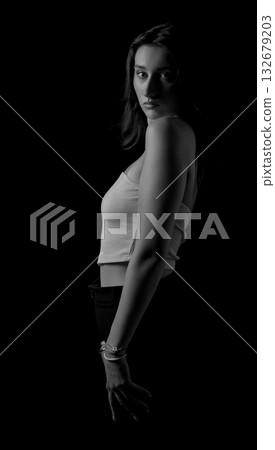 Fashion model posing in a black and white portrait with dark background Fashion model posing in a black and white portrait with dark background 132679203