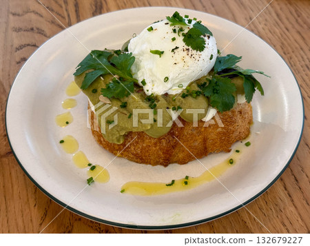 Avocado toast with poached egg and herbs on plate. Healthy breakfast, modern cuisine and fresh culinary aesthetics with natural ingredients 132679227