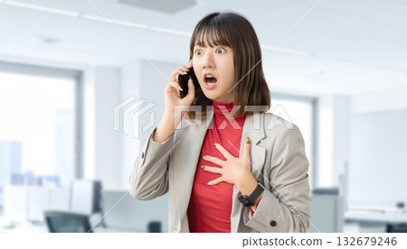 A woman/businesswoman surprised while talking on her smartphone 132679246