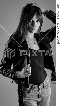 Fashion model wearing leather jacket and jeans posing in studio Fashion model wearing leather jacket and jeans posing in studio 132679305