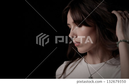 Fashion model touching her hair and looking down 132679350