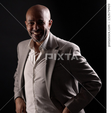 Smiling african american businessman posing with hands in pockets on black background 132679409
