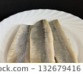Close-up of a lightly salted herring fillet on a white plate. Healthy, natural food. 132679416