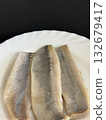 Close-up of a lightly salted herring fillet on a white plate. Healthy, natural food. 132679417