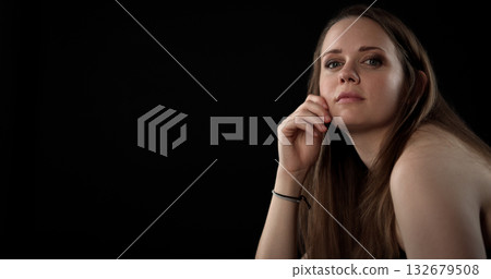 Pensive young woman posing on black background Pensive young woman posing on black background 132679508
