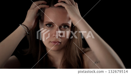 Young woman touching her hair with hands on a black background Young woman touching her hair with hands on a black background 132679514