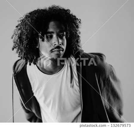 Young african-american man with curly hair looking away posing in studio shot Young african-american man with curly hair looking away posing in studio shot 132679573