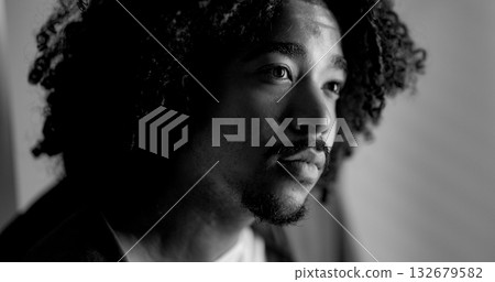 Young african-american man with curly hair looking away and thinking Young african-american man with curly hair looking away and thinking 132679582