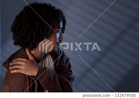 Young african-american man with curly hair posing in studio with black background 132679588
