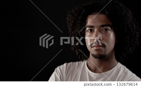 Serious young african-american man with curly hair posing on black background Serious young african-american man with curly hair posing on black background 132679614