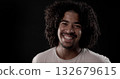Young african-american man with curly hair smiling on black background 132679615