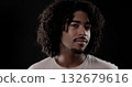 Young african-american man with curly hair posing on dark background 132679616