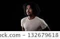 Young african-american man with curly hair looking up on black background 132679618