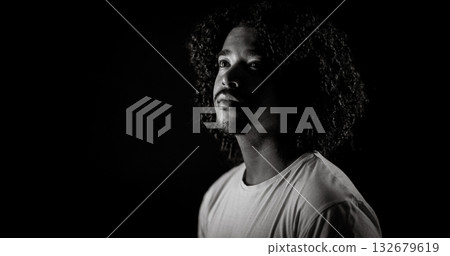 Young african-american man with curly hair looking up in black and white Young african-american man with curly hair looking up in black and white 132679619