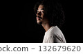 Young african-american man with curly hair looking up on black background 132679620