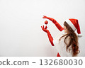 A cheerful figure dressed in a vibrant and festive Santathemed outfit gracefully balances a shiny red ornament, perfectly embodying the joyous essence and spirit of the holiday season 132680030