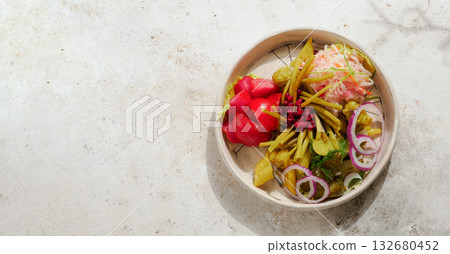 Assorted snacks from fermented cabbage, cucumbers and tomatoes, green bean. Decorated cranberry. Fermented healthy food concept. Pickled cucumbers, marinated tomatoes. Top view or flat lay. Assorted snacks from fermented cabbage, cucumbers and tomatoes, green bean. Decorated cranberry. Fermented healthy food concept. Pickled cucumbers, marinated tomatoes. Top view or flat lay. 132680452