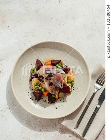 Restaurant dish with fish snack. Salted herring, potatoes, beets, carrots, green peas decorated microgreens. Pickled Herring Fish. Top view or flat lay Restaurant dish with fish snack. Salted herring, potatoes, beets, carrots, green peas decorated microgreens. Pickled Herring Fish. Top view or flat lay 132680454