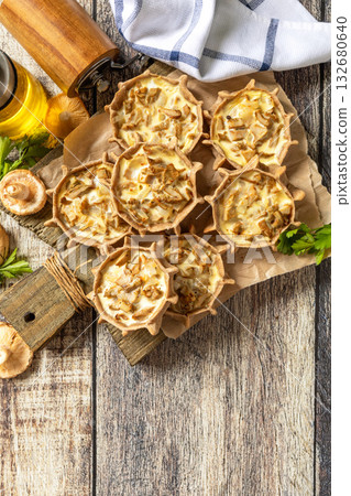 Rustic mushroom tartlets on wooden cutting board perfect for appetizers. Top view flat lay. Rustic mushroom tartlets on wooden cutting board perfect for appetizers. Top view flat lay. 132680640
