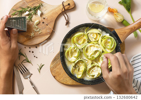 Culinary preparation of zucchini rolls with cheese in rustic kitchen setting. Top view flat lay background. 132680642