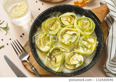 Delicious zucchini roll ups in creamy cheese sauce for gourmet meal presentation. 132680646