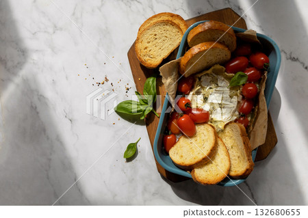 Fresh caprese appetizer with feta, tomatoes, and basil on rustic marble background. Fresh caprese appetizer with feta, tomatoes, and basil on rustic marble background. 132680655