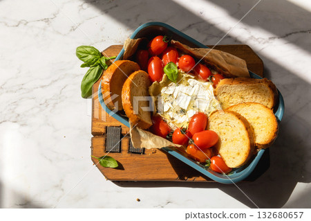 Fresh caprese appetizer with feta, tomatoes, and basil on rustic marble background. Top view flat lay background. Copy space. Fresh caprese appetizer with feta, tomatoes, and basil on rustic marble background. Top view flat lay background. Copy space. 132680657