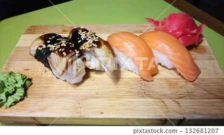 A plate of sushi with a piece of ginger on top. A plate of sushi with a piece of ginger on top. 132681207