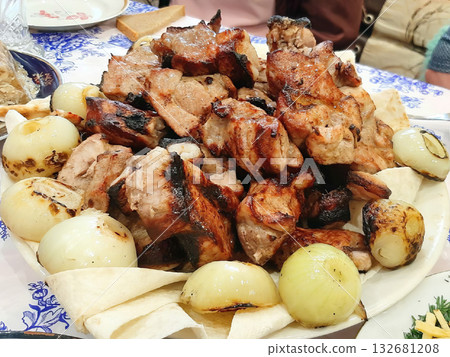A plate of meat and onions. The meat is cooked and the onions are sliced. 132681208