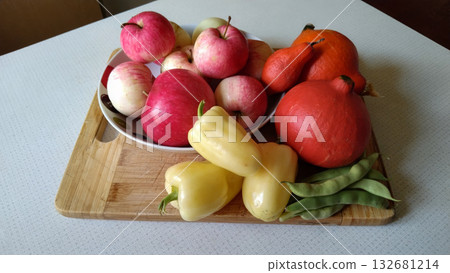 A wooden board with a variety of fruits and vegetables on it. 132681214