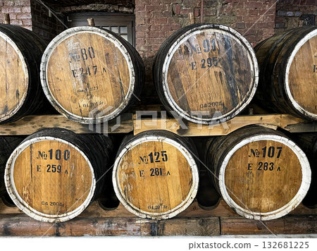 A brick oven sits in front of a row of barrels. A brick oven sits in front of a row of barrels. 132681225