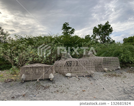 Trap for crab fish lobster lobsters cages braided from bamboo lie on a sandy shore 132681924