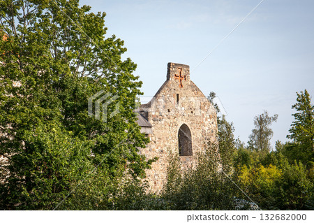 Ancient Stone Church Ruins with Cross Surrounded by Green Trees on a Sunny Day 132682000