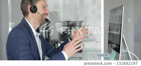Man in headset talking during online video call, working in office, consulting remote customers, providing technical support. Business people concept 132682197
