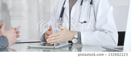 Doctor consulting patient, discussing diagnosis, using digital tablet in modern medical clinic. Medicine and health care Doctor consulting patient, discussing diagnosis, using digital tablet in modern medical clinic. Medicine and health care 132682223