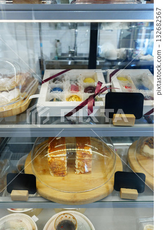 Colorful desserts displayed in a glass case at a bakery during the afternoon 132682567