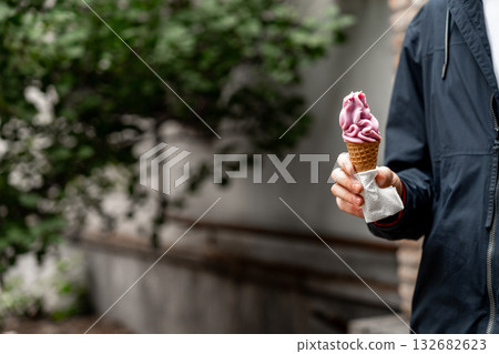 Enjoying a delicious cone of soft-serve ice cream outdoors on a sunny day 132682623