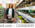 Man shopping for groceries in a modern supermarket aisle filled with jars 132682695