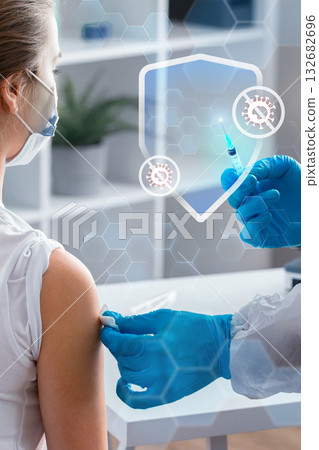 A healthcare professional in blue gloves gives a vaccine to a patient in a clinic environment A healthcare professional in blue gloves gives a vaccine to a patient in a clinic environment 132682696