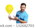 Man smiles and points at a bright yellow paddle in a studio setting 132682703