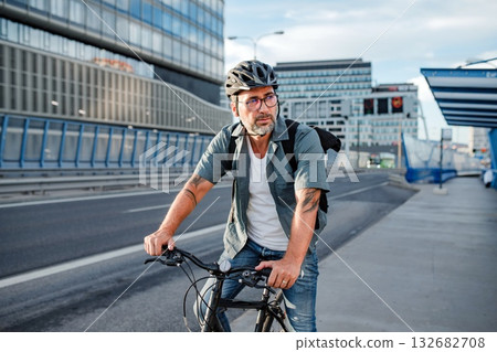 Male cyclist riding bike down the street. 132682708