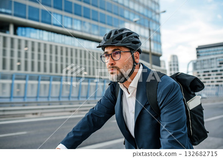City commuter riding bike to office, wearing backpack and helmet. City commuter riding bike to office, wearing backpack and helmet. 132682715