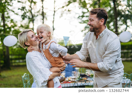 Potrait of young family during grill garden party. Potrait of young family during grill garden party. 132682744