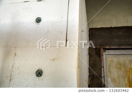 Insulation work of house walls with styrofoam sheets. Insulation work of house walls with styrofoam sheets. 132683462